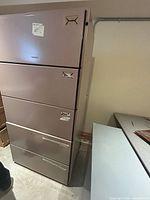 Full view of beige five-drawer lateral filing cabinet showing drawer fronts, handles and overall condition