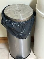 Full view of stainless steel trash can showing pedal and lid