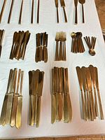 Full layout showing multiple stacks of knives, forks, spoons and possible napkin rings