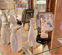 Group view showing cats, penguins, plaque, carved figure