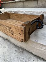 Side view showing stencilled markings and rope handle