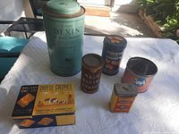 All six vintage advertising containers displayed on table