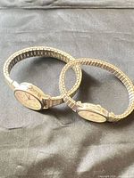 Two stainless steel Timex watches side by side showing expansion bands and faces