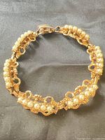 Bracelet closed, showing filigree links and faux pearls