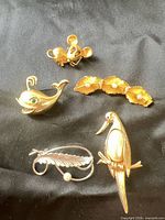 Group shot of all five brooches on black fabric