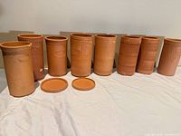 Front view of eight terracotta wine coolers and two lids