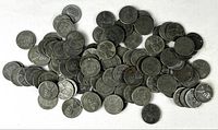 Pile of approximately 100 steel cents spread on white surface