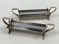 pair of silver holders top view showing pierced design and handles