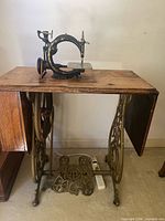 Full view of machine mounted in cabinet showing treadle base and table