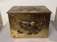 Front view showing duck repousse scene and handles