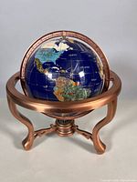 Front view of lapis gemstone globe on copper stand