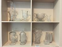 Entire lot displayed in shelving showing all ten pressed glass pieces