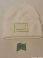 Front view of white beanie showing neon green embroidered logo