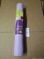 Rolled purple Gaiam yoga mat in wrap