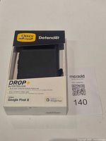 Front of sealed OtterBox Defender DROP+ box showing case through window and Google Pixel 8 compatibility