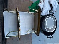 Undersides of both folding tray tables with gold-tone metal legs folded