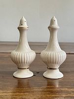 Front view of both shakers showing shape, ribbing, and gold trim