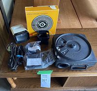 All components laid out: projector, tray, viewer, remote/power cord, box