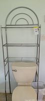 Full view of chrome metal rack positioned over toilet