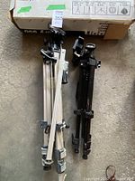 Both folded tripods side by side showing leg colors and overall condition
