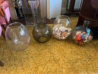 Front view of all four large glass vases lined up on floor