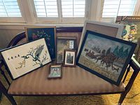 Group view of all framed artworks on settee