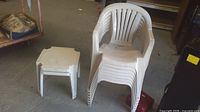 Stacked plastic chairs next to side table