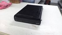 Front and top view of black Wii U console showing disc slot and indicator lights