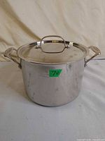 Front view of stainless stock pot with lid and side handles