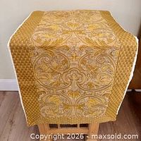 Full view of gold and ivory jacquard table runner draped to show pattern and lining