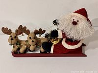 Front view showing Santa, sleigh, two reindeer, gold gift
