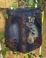 Front view of Desigual patchwork denim mini skirt showing overall design