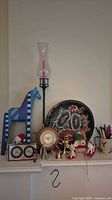Full lot on mantel with horse, tray, candlestick, barometer, gauge, plush, horns, mug and figurines