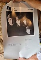 Front view of full poster held up showing album image and text