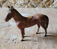 Full side view of cast iron horse figurine on wooden surface