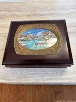 Closed box top showing photo window with ornate border