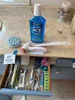 Mouthwash, round pill organizer, long-handle scrubber, drawer with contents