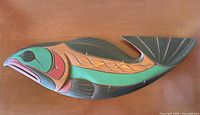 Full view of carved salmon wall plaque on tabletop