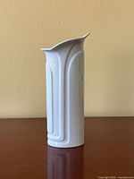 Full side view of white ceramic vase showing raised relief pattern