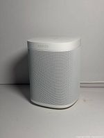 Front-angled view of white Sonos One speaker showing grille and branding