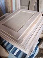 Stack of unfinished cabinet doors showing maple frames and hardboard panels