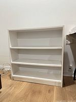 Front view of white bookcase showing three shelf levels