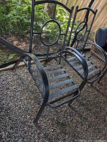 Two black metal patio chair frames front view showing design and condition