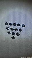 Triangular arrangement of 13 round blue sapphires under lighting