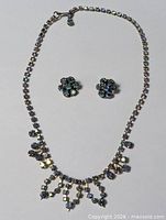 Full view of necklace and earrings set laid flat
