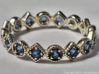 Front view of sterling silver eternity ring showing blue stones and milgrain detail