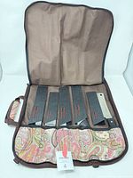 Open roll case showing five knives in edge guards and paisley interior