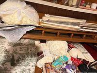 Wide view of yarn skeins, packaged embroidery fabric and toile storage box on shelf