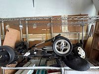Folded golf cart on shelf showing wheels and frame
