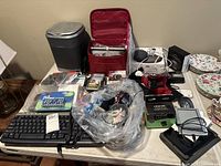 Overview of table with speaker, DVD player in case, keyboard, mice, cables, battery pack and accessories